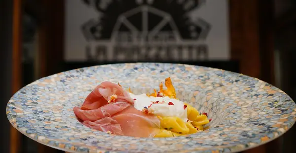 Un piatto della casa sotto l'insegna dell'osteria